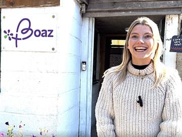 Woman stood smiling outside Boaz charity building