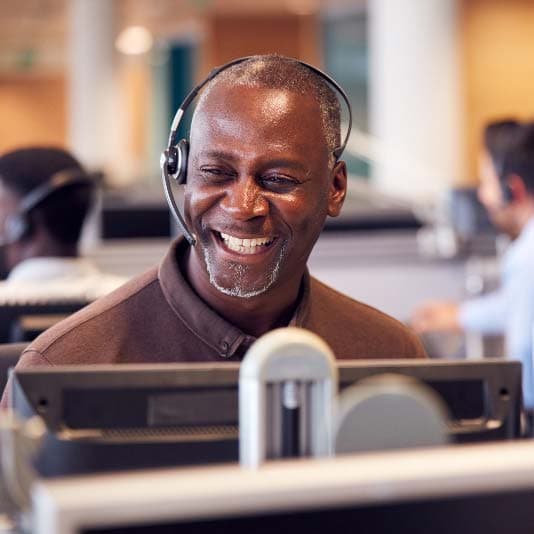 Man working in call centre and smiling