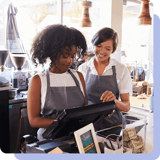 Two women working at the till of a coffee shop