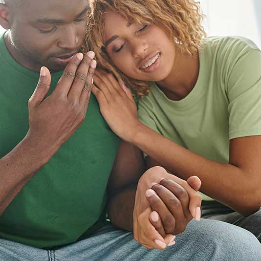 Couple on sofa holding hands