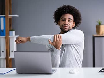 Man stretching whilst working from home