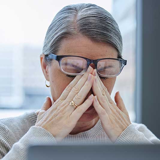 Lady with brain fog holding hands to head