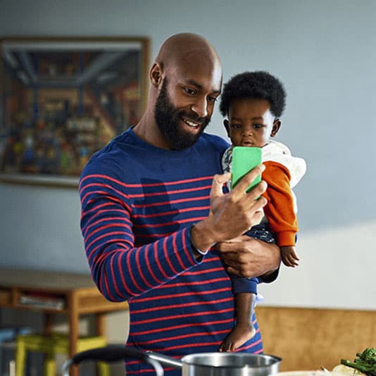 Father holding daughter on gp video call