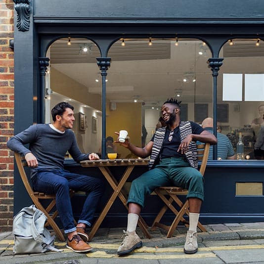 Two men talking about their anxiety outside coffee shop