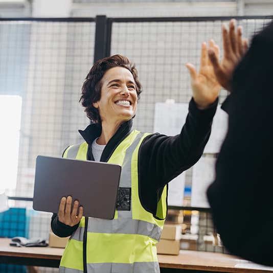 Woman factory working giving her colleague a high five