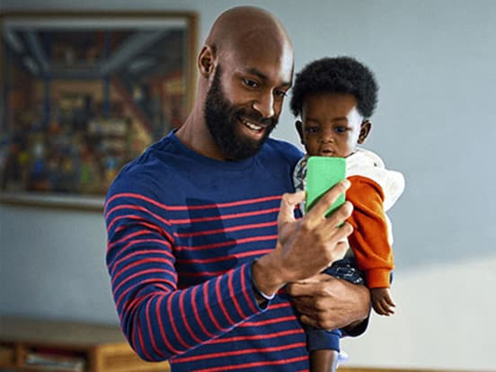 Father holding daughter on gp video call