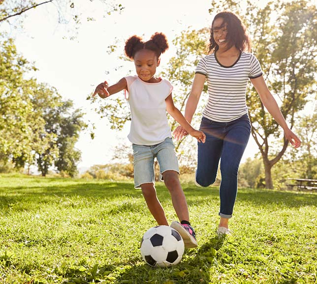 Mother and daughter playing football